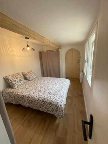 um quarto com uma cama e piso em madeira em Maisonnette avec Jardin à Ares em Arès