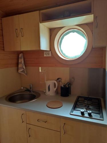 a small kitchen with a sink and a window at Roulotte équipée - Gite La Pâquerie in Le Louroux-Béconnais