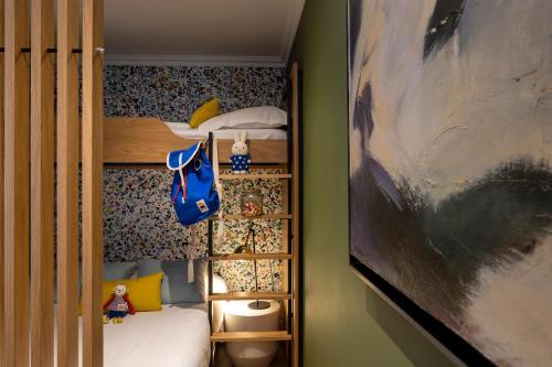 a small bedroom with bunk beds and a painting at Hotel Le Colombier in Colmar