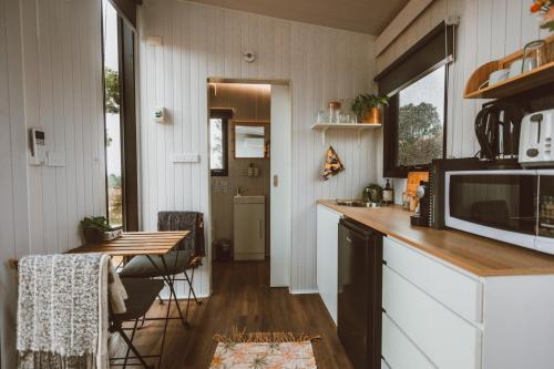 a kitchen with a counter and a table with chairs at River Ridge Tiny House in South Arm