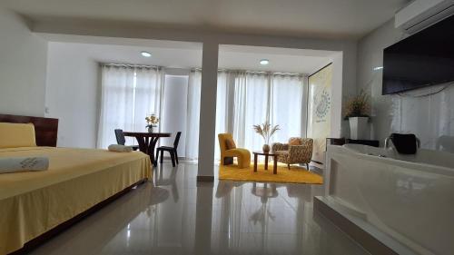 Hotel Betania في جيان: غرفة نوم بسرير وطاولة وكراسي