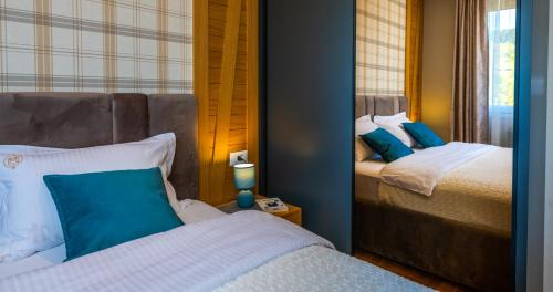 1 Schlafzimmer mit 2 Betten und einem Spiegel in der Unterkunft Luxury Mountain Getaway MM2 in Kolašin