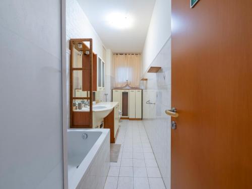 baño con bañera grande y lavamanos en I Host Apartment - Abeti 15 en Baggio