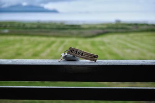 a small bird sitting on a railing with a sign that reads risk at Marmelkroken AS in Risøyhamn