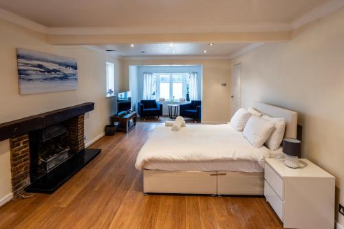 a bedroom with a large bed and a fireplace at Fernbanks in Ferndown