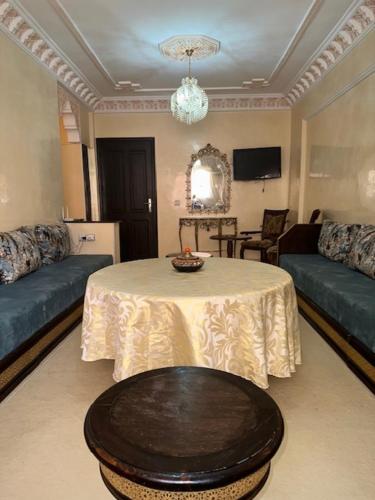 a living room with a table and a couch at Aicha Appartement in Marrakesh