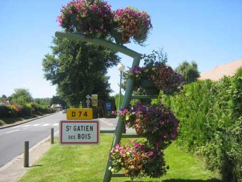 a pole with flowers and a sign on the side of a road at gîte de la scierie in Saint-Gâtien-des-Bois