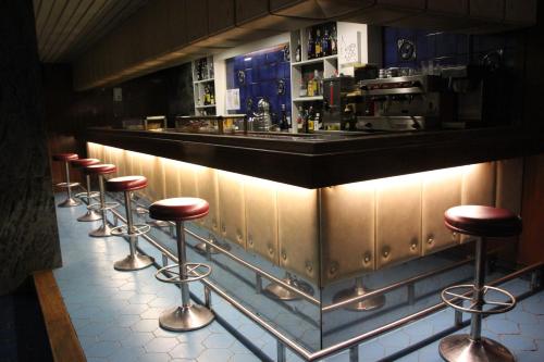 a row of stools at a bar in a restaurant at Hotel Marqués de Santillana in Torrelavega