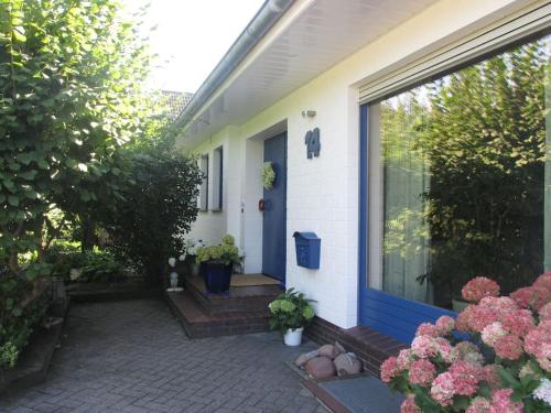 uma casa com uma porta azul e algumas flores em Ferienwohnung Hude em Hude