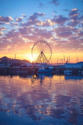 a ferris wheel sitting in the water at sunset at gîte de la scierie in Saint-Gâtien-des-Bois