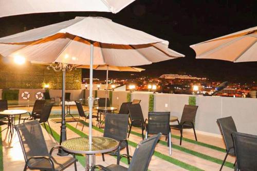 a patio with tables and chairs and umbrellas at بالم السكنية in Abha