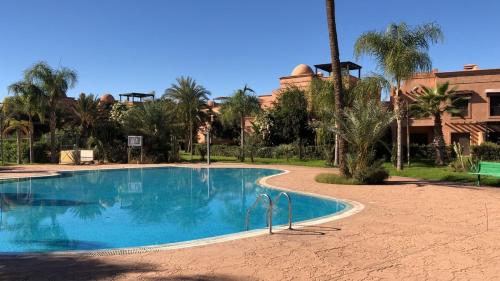 - une piscine dans un complexe avec des palmiers dans l'établissement DIANA, à Marrakech