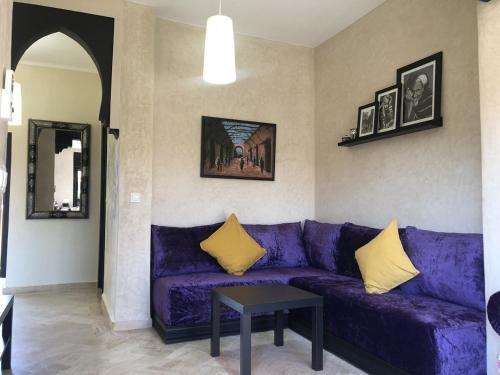 - un canapé violet avec des oreillers jaunes dans le salon dans l'établissement DIANA, à Marrakech