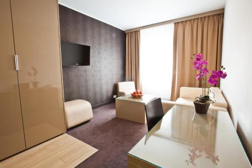 a hotel room with a living area with a table at Platinum Apartments Aparthotel in Poznań