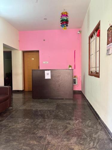 a pink wall in a room with a reception desk at The Grand Hospitality in Coimbatore