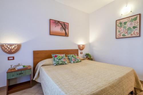 um pequeno quarto com uma cama e uma mesa de cabeceira em Rosa's Apartment em Isola Rossa