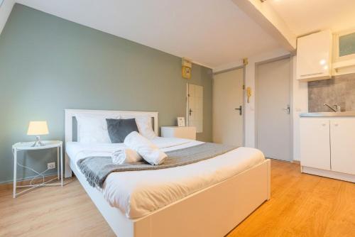 une chambre avec un grand lit blanc dans une pièce dans l'établissement Functional studio and equipped, à Lille