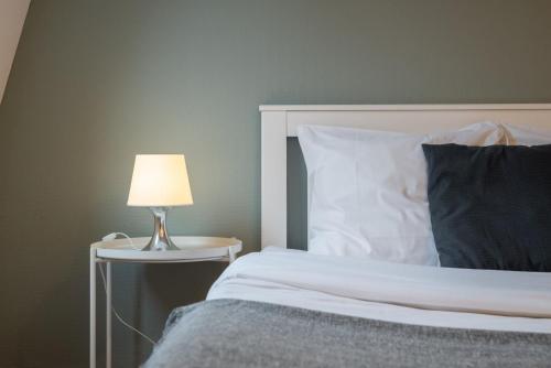 une chambre avec un lit avec une lampe sur une table dans l'établissement Functional studio and equipped, à Lille