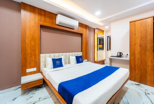 a bedroom with a large bed with blue pillows at HOTEL AURA GRANDE in Indore