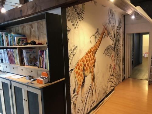 a mural of a giraffe on a wall in a library at Domaine de la Haute Justerie - piscine & billard à l’orée des bois - Loire Valley in Fondettes