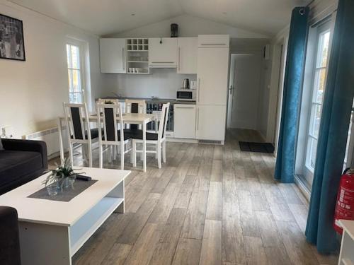 a living room and kitchen with a table and chairs at Ursand Resort & Camping in Vänersborg