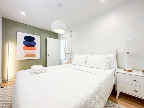 a bedroom with a large white bed and a painting at 1 BR exceptional house PCHL-TOP in Topanga