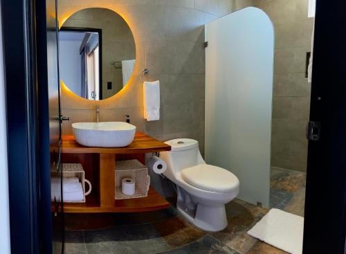a bathroom with a sink and a toilet and a mirror at Arenal Monara in Fortuna
