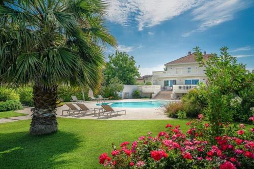 a house with a palm tree and a swimming pool at Le Dimore di Giò in campagna in Ortona