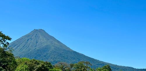 a mountain with trees in the foreground at Arenal Monara in Fortuna