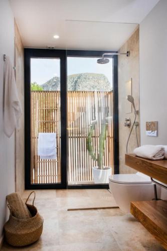 a bathroom with a tub and a toilet and a plant at YourHouse Iris House in Colonia de Sant Pere