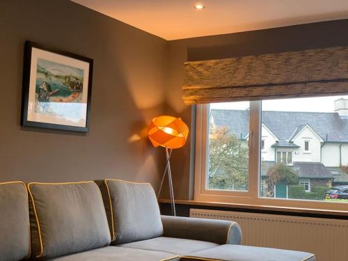 a living room with a couch and a window at Staintons, in Bowness Centre, Lake Access in Bowness-on-Windermere