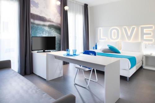 a bedroom with a bed and a desk with a tv at Love Boat Hotel - The Original in Riccione