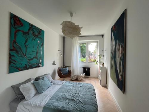 弗次瓦夫的住宿－AAart Apartment，卧室配有一张床,墙上挂有绘画作品