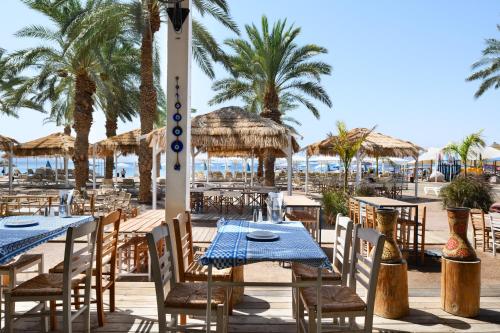 a restaurant with tables and chairs on the beach at Royal Beach Eilat by Isrotel Exclusive in Eilat