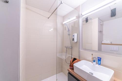 een witte badkamer met een wastafel en een douche bij Montempô Bordeaux Centre - Bassins à flot in Bordeaux