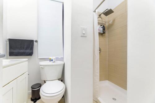 y baño blanco con aseo y ducha. en Modern NY Style 2BD Apartment in Upper East Side Manhattan en Nueva York