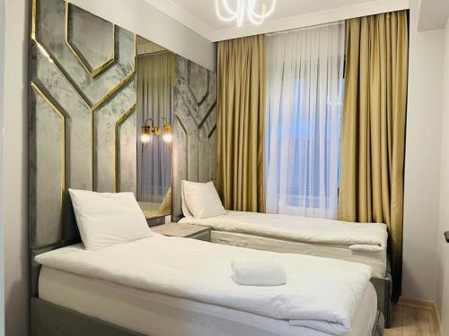 a hotel room with two beds and a window at Cantrmen Suites in Istanbul