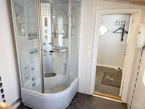 y baño con ducha y puerta de cristal. en Cosy cottage located close to a bay in Skappevik, en Bergkvara