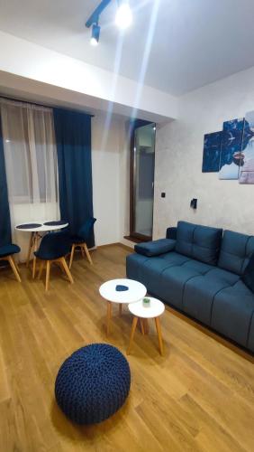 a living room with a blue couch and a table at Studio Amore by Montebello in Zlatibor