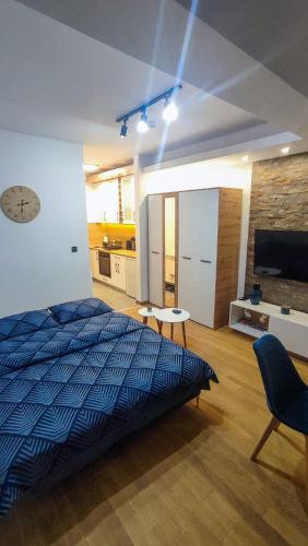 a bedroom with a bed and a clock on the wall at Studio Amore by Montebello in Zlatibor