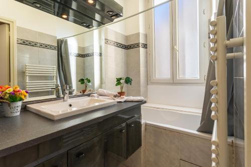 une salle de bain avec un lavabo, un miroir et une baignoire dans l'établissement Le Saint-Pierre PET231 2P, à Cannes