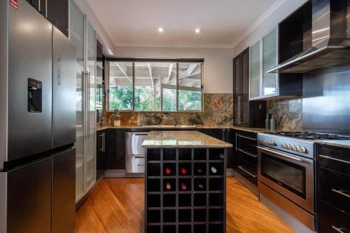 a kitchen with stainless steel appliances and a counter at 'The Moondah Manor' A Poolside Family Retreat in Melbourne