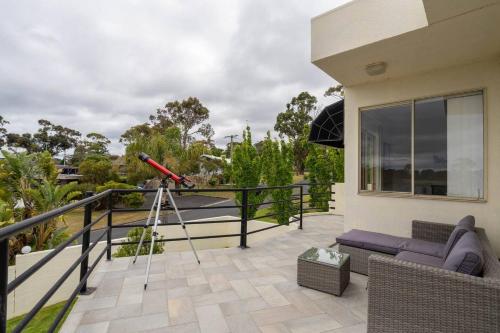 a camera on a tripod on the balcony of a house at 'The Moondah Manor' A Poolside Family Retreat in Melbourne