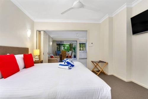 道格拉斯港Escape for Two - A Boutique Tropical Treasure的卧室里有一张白色的大床，上面有红色的枕头