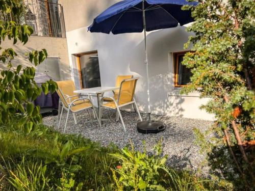 a patio with a table and chairs and an umbrella at Casa Acletta - die Ferienwohnung in Valbella in Valbella