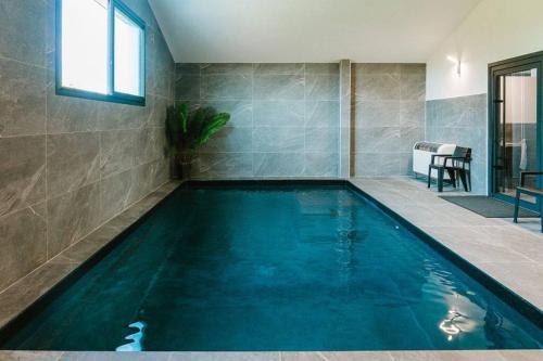 - une piscine dans une chambre dotée d'un mur en carrelage dans l'établissement Loft avec Piscine SPA 6personnes, à Lespignan