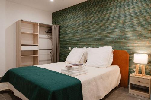 - une chambre dotée d'un lit avec un mur vert dans l'établissement Loft avec Piscine SPA 6personnes, à Lespignan