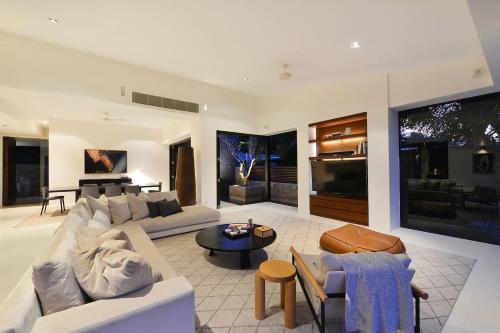 a living room with a couch and a table at 61 Murphy Street - Luxury Holiday Home in Port Douglas