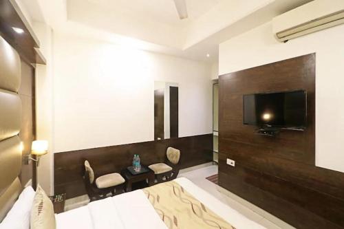 a bedroom with a tv and a bed and a table at HOTEL AEROPATH INN in New Delhi