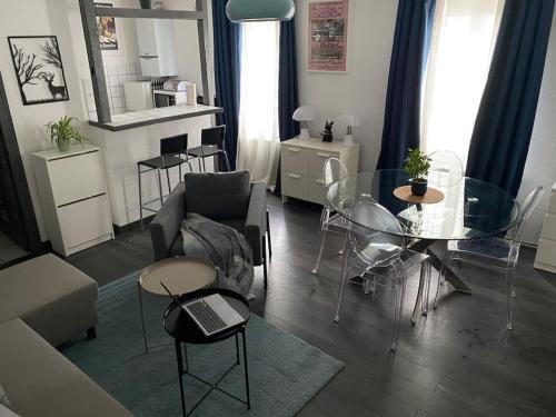 ein Wohnzimmer mit einem Sofa und einem Glastisch in der Unterkunft Appartement privé 2 pièces 42m proche centre in Schiltigheim